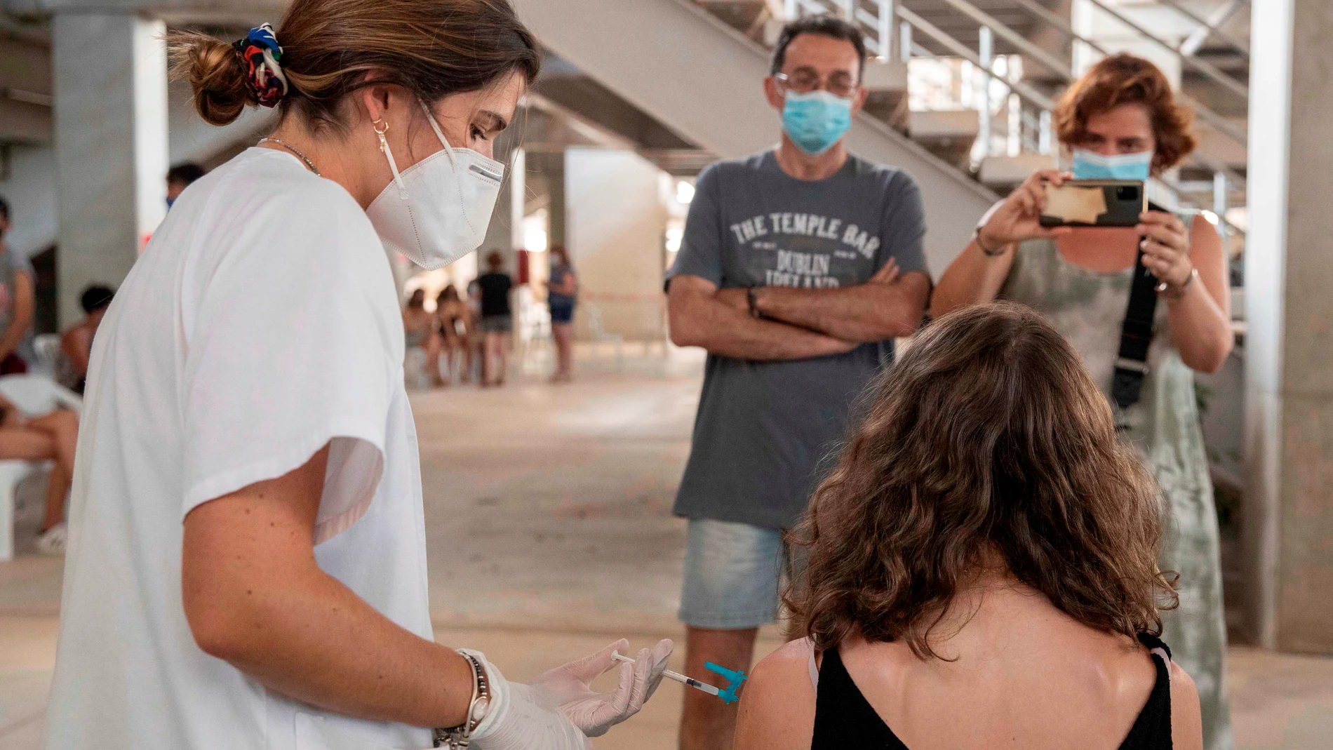Una enfermera administra la vacuna Moderna a una joven en el estadio Enrique Roca de Murcia