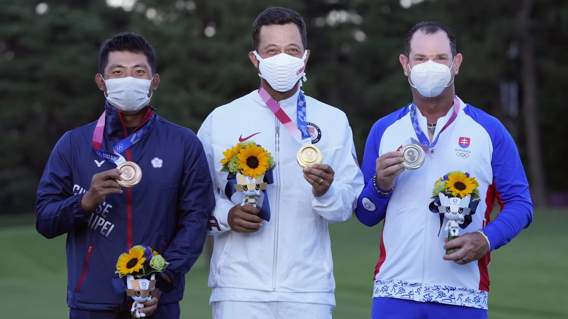 El campeón olímpico de golf, Xander Schauffele, posa junto a Pan Cheng y Rory Sabatini