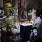 Mourners take pictures of electric candles resting in front of a portrait of Haiti's assassinated President Jovenel MoÃ¯se, during a memorial service at Notre Dame d'Haiti Catholic Church on Thursday, July 22, 2021, in the Little Haiti neighborhood of Miami. Miami's Haitian Consul General hosted the service for members of the city's large Haitian community to pray for the troubled nation and pay their respects to the president, who was slain in a July 7 attack at his home which left his wife seriously wounded. (AP Photo/Rebecca Blackwell)