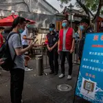 Gente con mascarillas para entrar en un mercado en China