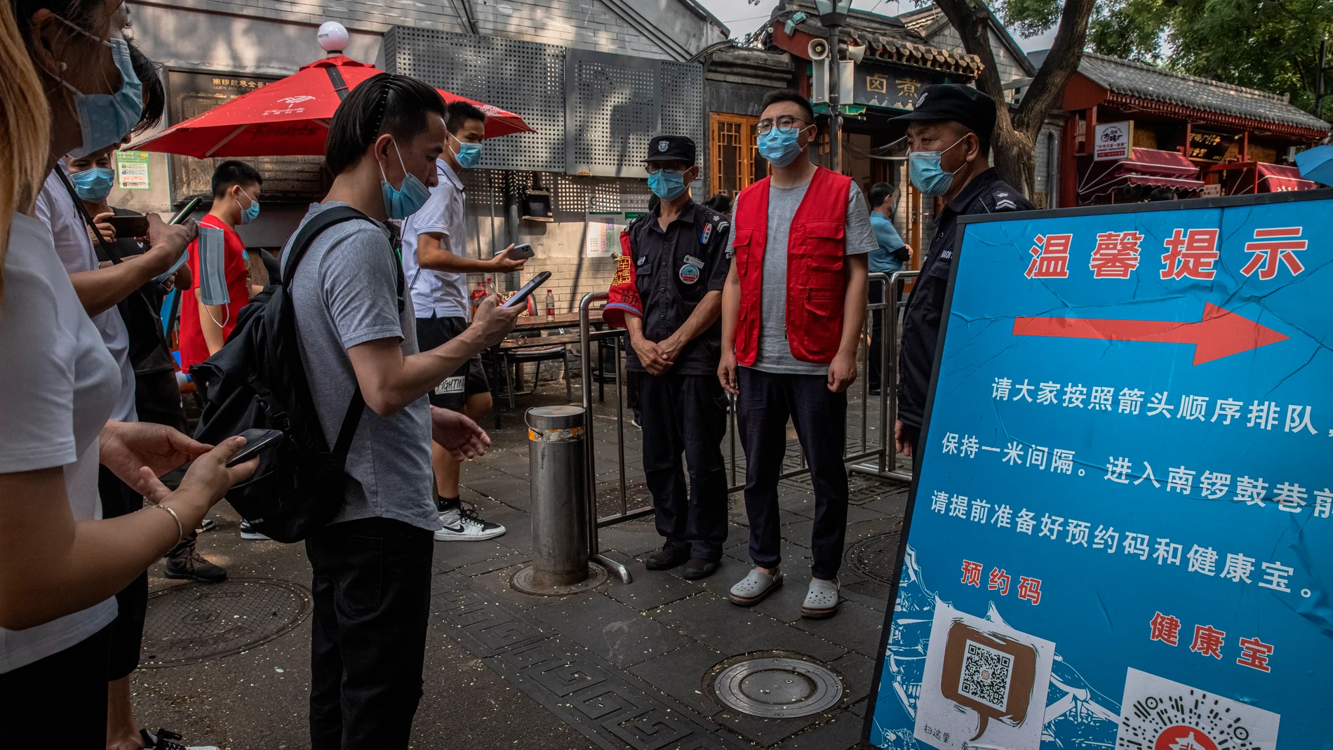 Gente con mascarillas para entrar en un mercado en China