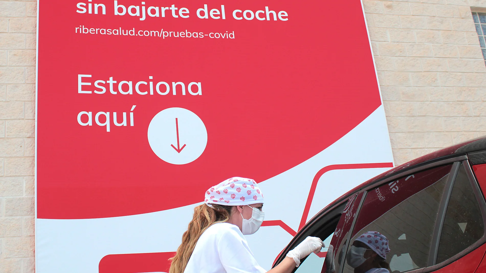 Una enfermera toma una muestra al ocupante de un vehículo