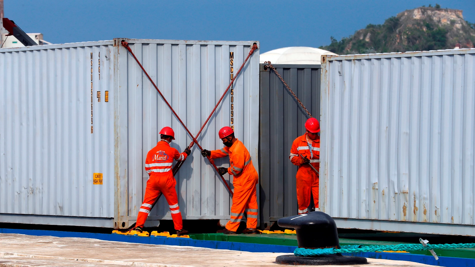 Trabajadores descargan los contenedores de un barco
