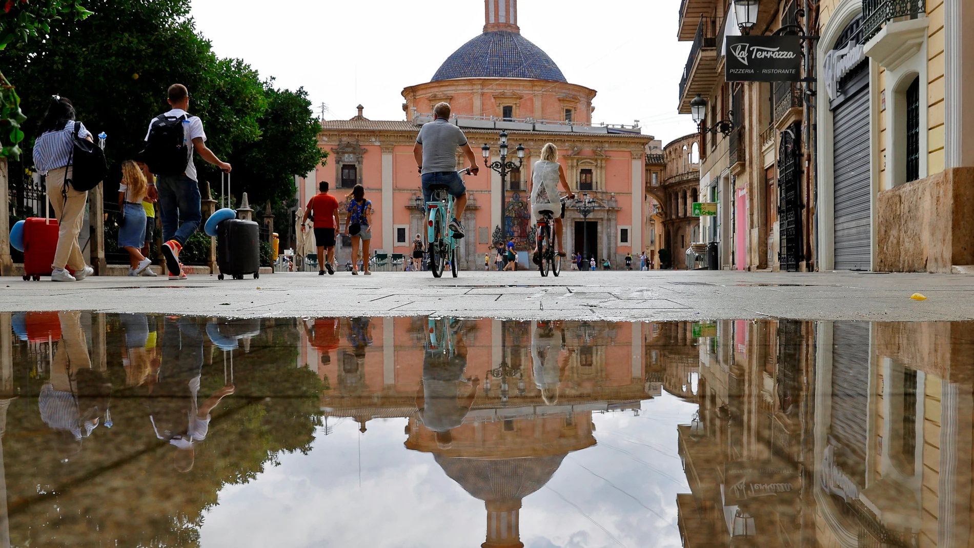 Varios turistas pasean por la plaza de la Virgen de Valencia, en el centro histórico de la ciudad