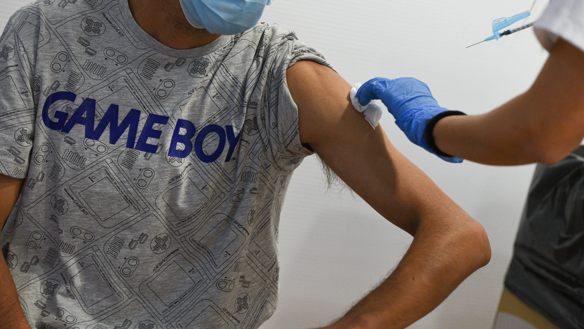 Un adolescente recibe la primera dosis de la vacuna Pfizer en el punto de vacunación de Xátiva, situado en el Hogar de los Jubilados