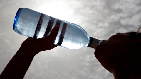 Una mujer bebe agua.