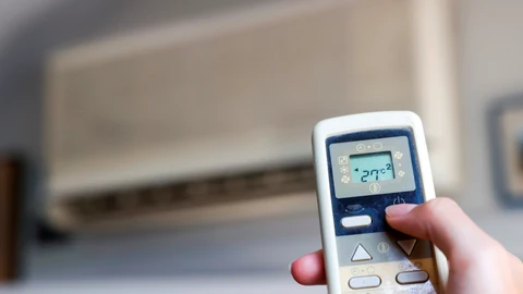 ¡Una persona enciende un aparato de aire acondicionado