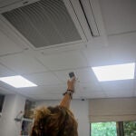 Una mujer enciende el aire acondicionado en una oficina