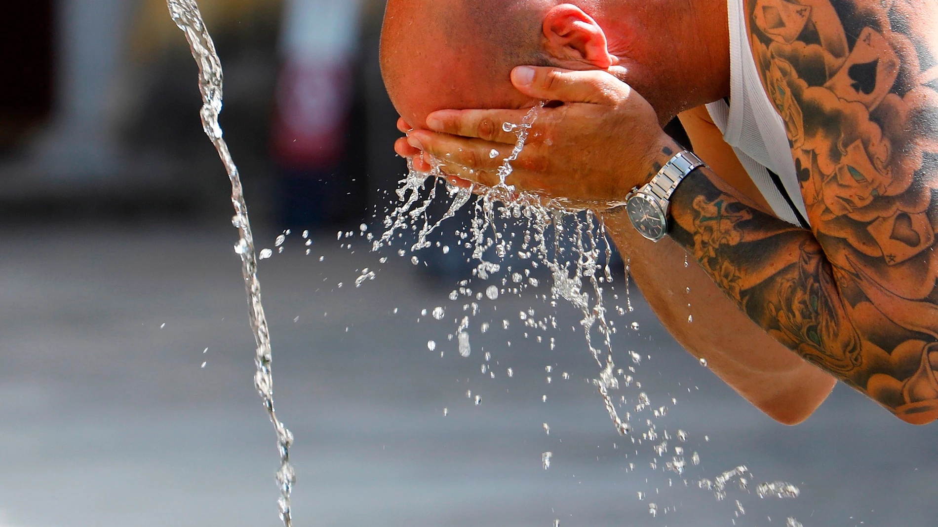 Un turista se refresca en el centro de Córdoba durante una ola de calor. EFE/Salas