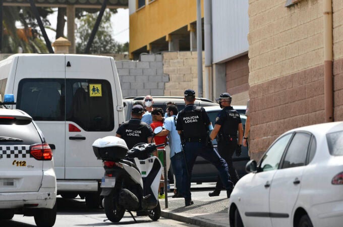 Varios agentes y vehículos de la Policía Local de Ceuta acompañan a menores no acompañados hacia una furgoneta