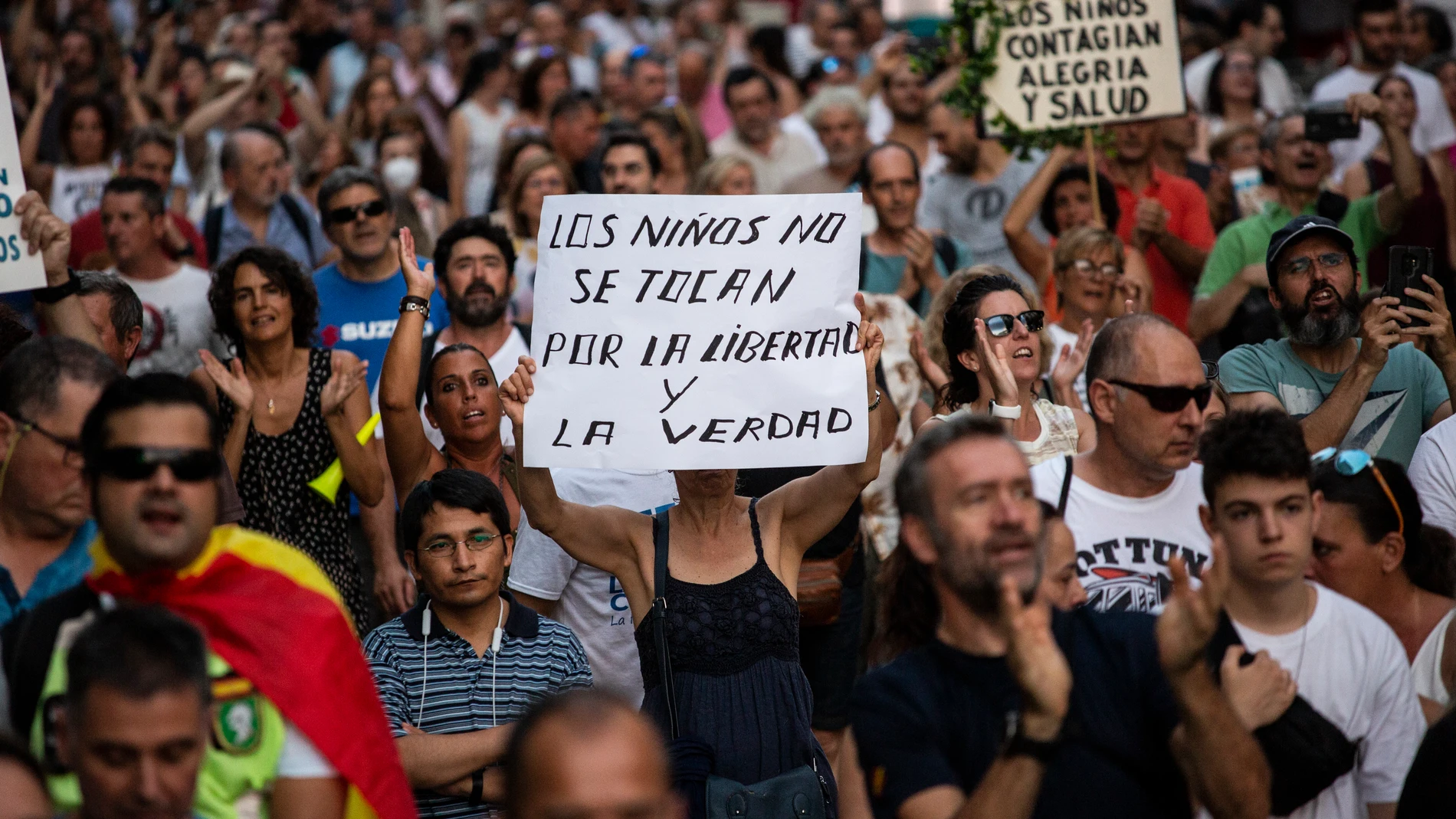 Un asistente lleva un cartel que dice "Los niños no se tocan, por la libertad y la verdad", durante una manifestación contra la vacunación contra la covid en niños el pasado día 14 en Madrid 14/08/2021