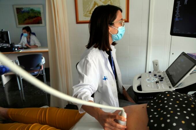 Una sanitaria hace una ecografía a una embarazada antes de ponerle la vacuna en el Hospital Vall d'Hebron de Barcelona