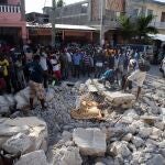 SENSITIVE MATERIAL. THIS IMAGE MAY OFFEND OR DISTURB People look at the body of a person lying on the debris after a 7.2 magnitude earthquake in Les Cayes, Haiti August 15, 2021. REUTERS/Estailove St-Val