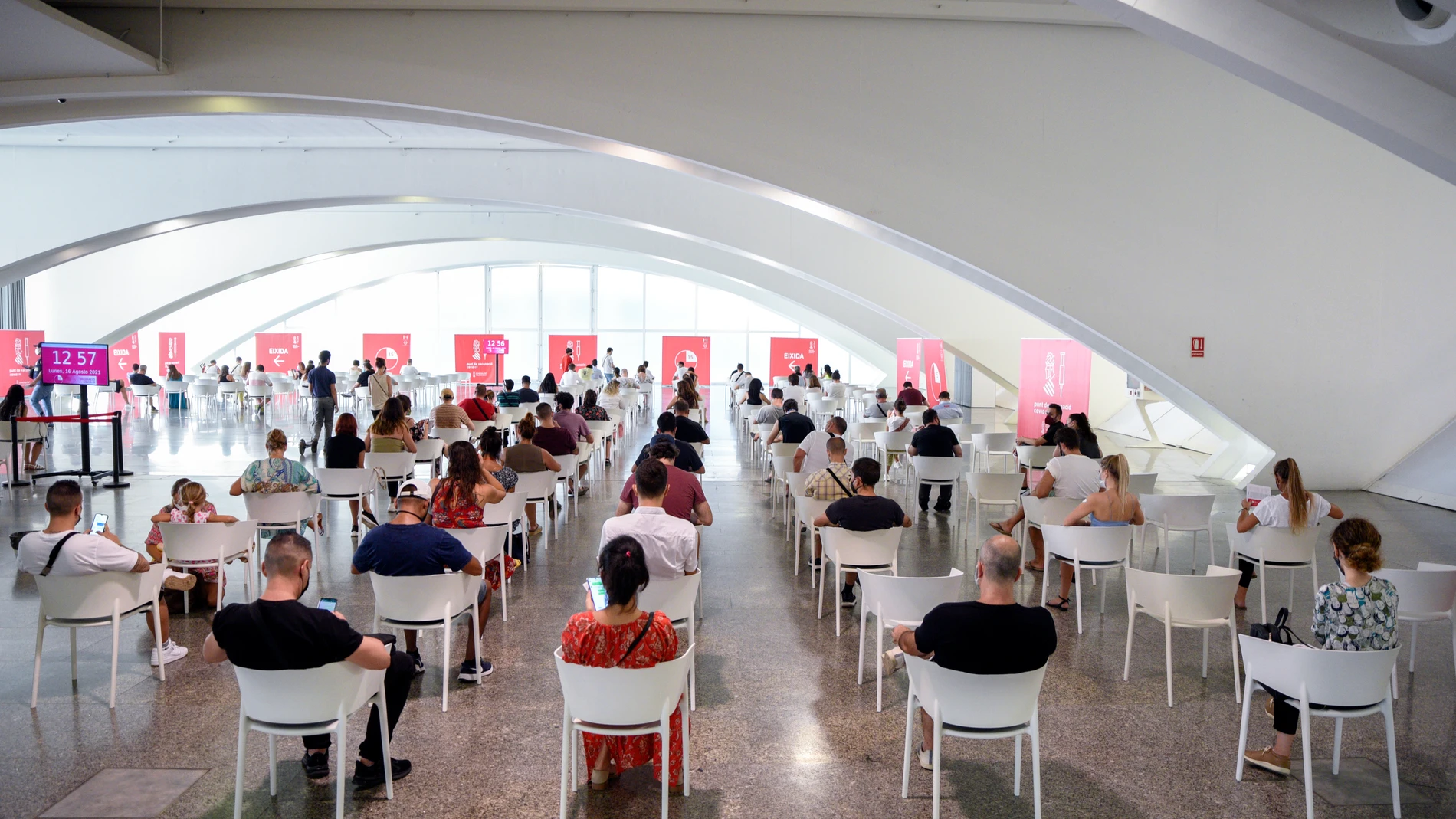 Decenas de adolescentes esperan después de vacunarse de la primera dosis de la vacuna Moderna en la Ciudad de las Artes