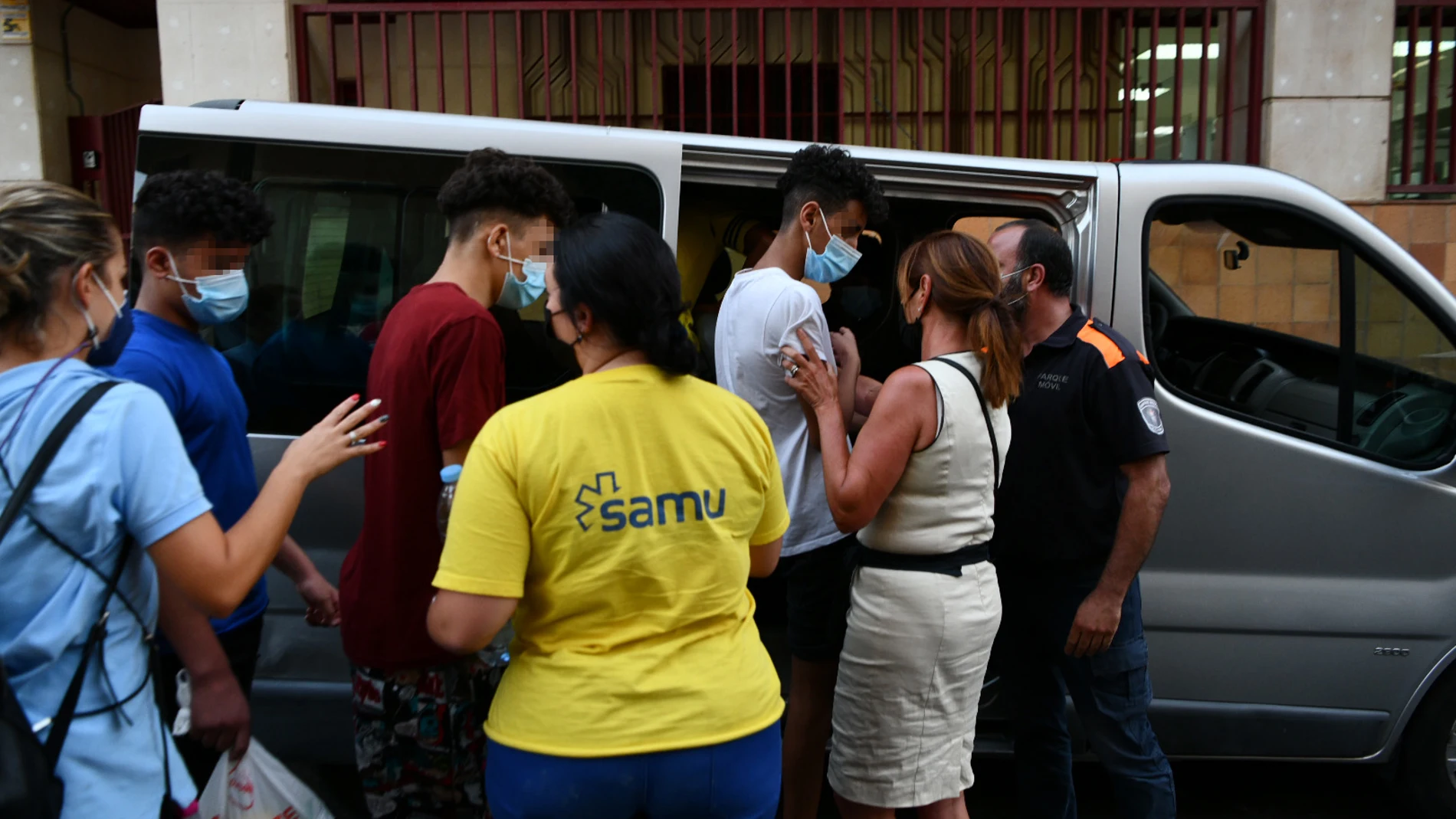 Trabajadores ayudan a tres de los menores marroquíes a las puertas del juzgado tras presentar una denuncia solicitando habeas corpus minutos antes de ser repatriados a su país de origen, en la frontera de Tarajal