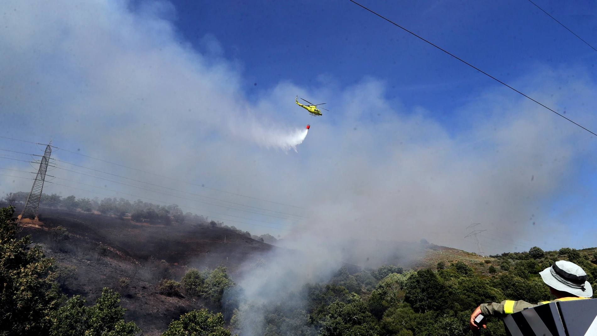 Un helicóptero trabaja para sofocar las llamas en el incendio de Carracedo