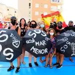 Varias personas participan en una protesta en defensa del Mar Menor al paso de la Vuelta Ciclista a España