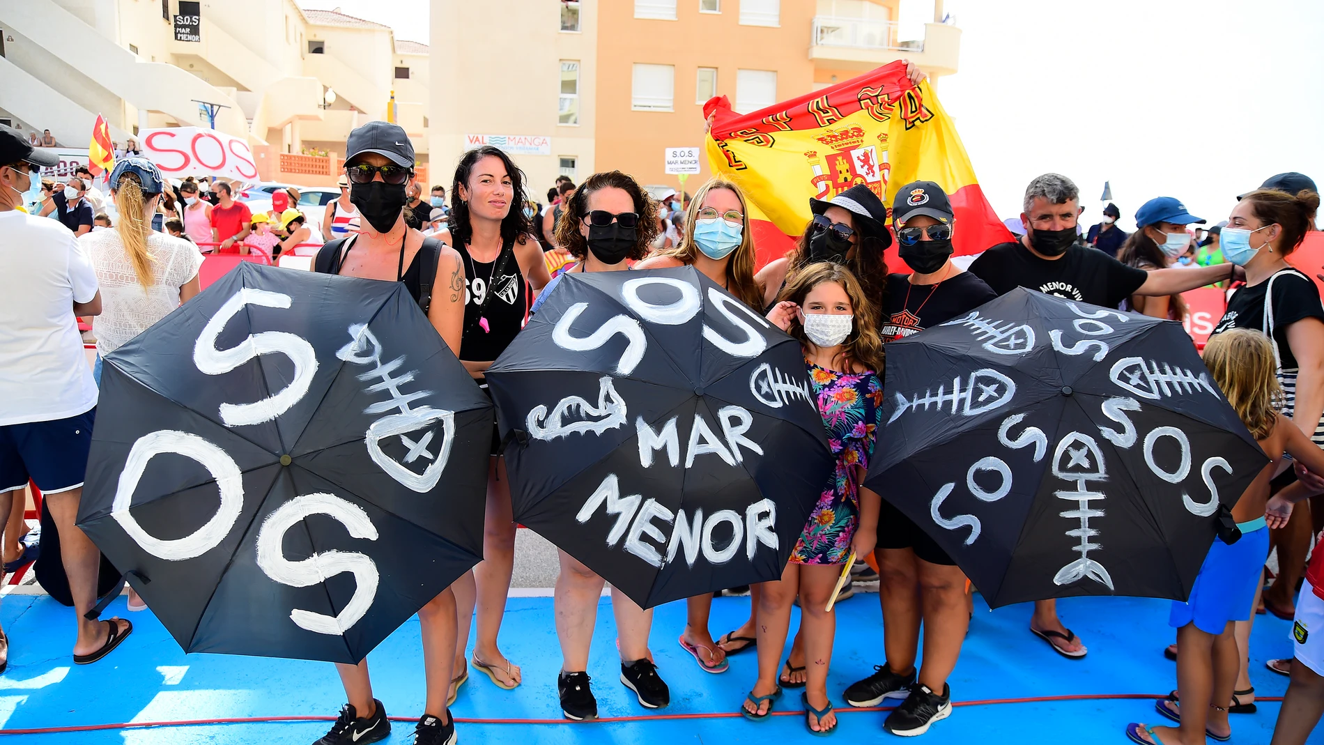 Varias personas participan en una protesta en defensa del Mar Menor al paso de la Vuelta Ciclista a España