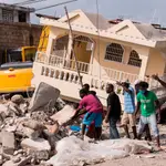 AME027. LES CAYES (HAITÍ), 21/08/2021.- Personas recuperan cosas que les puedan servir durante el trabajo de integrantes de la brigada Rescate Internacional Topos en un área afectada por el terremoto en Les Cayes (Haití). EFE/ Orlando Barria