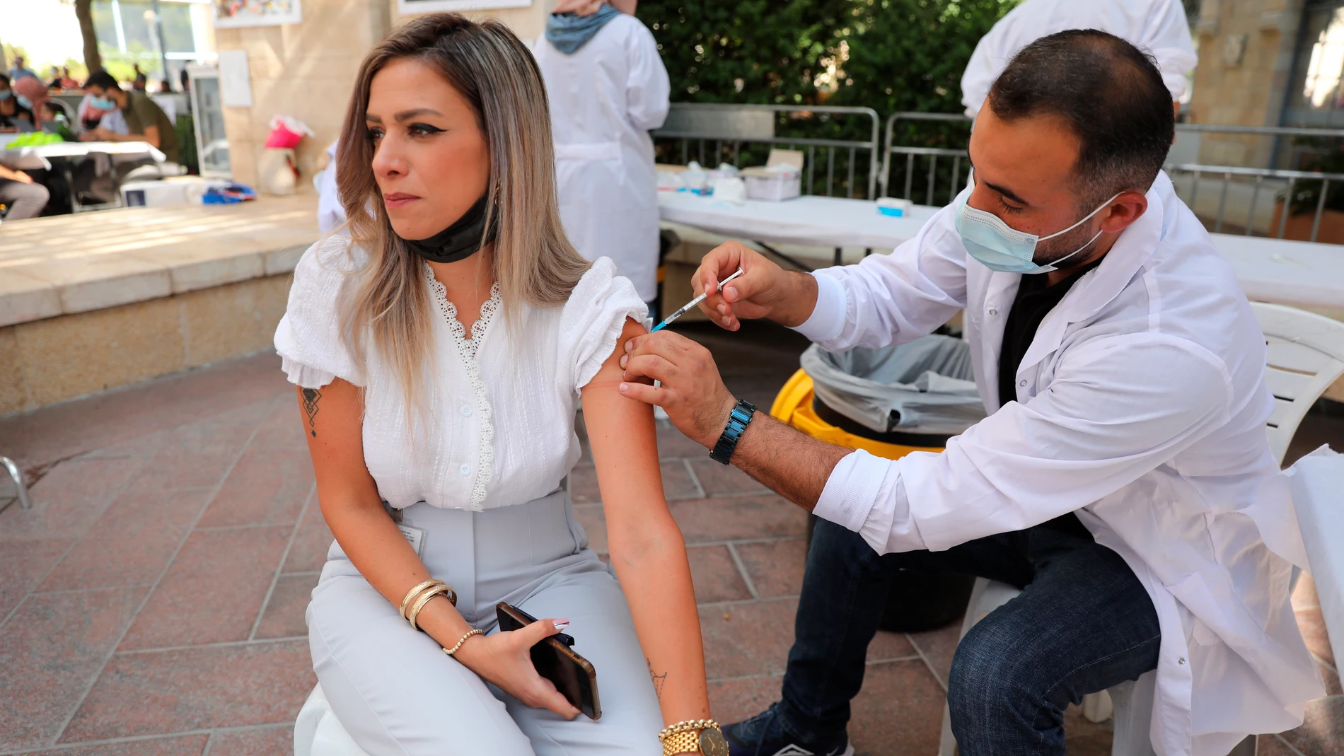 Un enfermero inyecta a una mujer la tercera dosis de la vacuna en Jerusalén