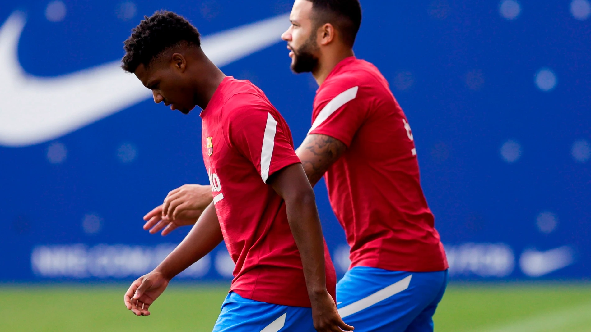 El delantero del FC Barcelona Ansu Fati (i) y el holandés Memphis Depay (d), durante el entrenamiento de la plantilla del FC Barcelona