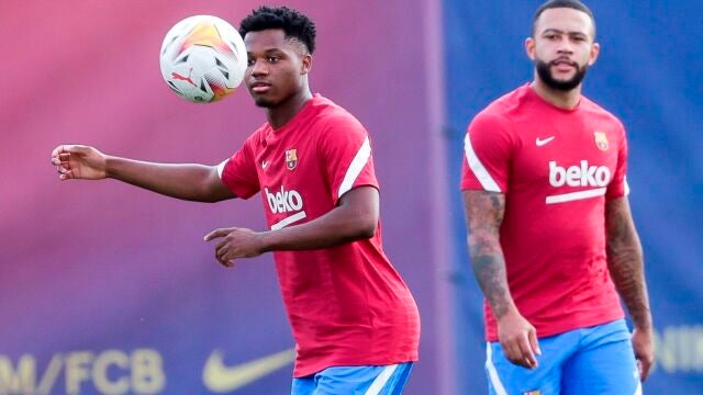 Ansu Fati controla un balón junto a Memphis Depay.