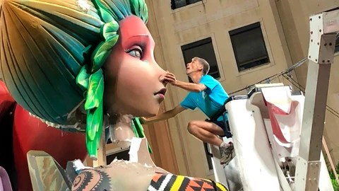 Un artista fallero coloca la cabeza del remate de la falla de la sección especial Sueca Literato Azorín que se desplomó tras la gran tromba de agua que descargó en Valencia el pasado lunes