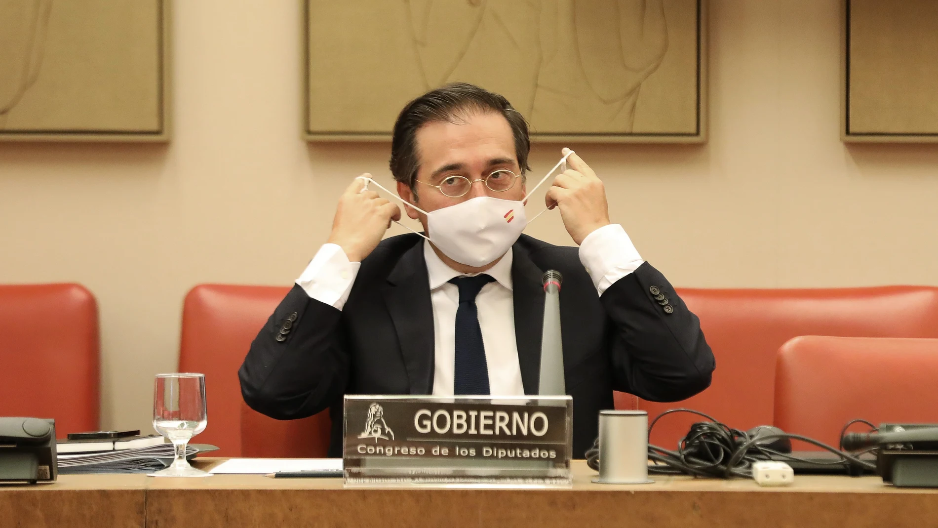 El ministro de Asuntos Exteriores, Unión Europea y Cooperación, José Manuel Albares, se pone la mascarilla durante una comparecencia en una rueda de prensa sobre la crisis de Afganistán