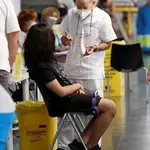 Un joven conversa con un sanitario en el punto de vacunación masivo instalado en el Wizink Center de Madrid