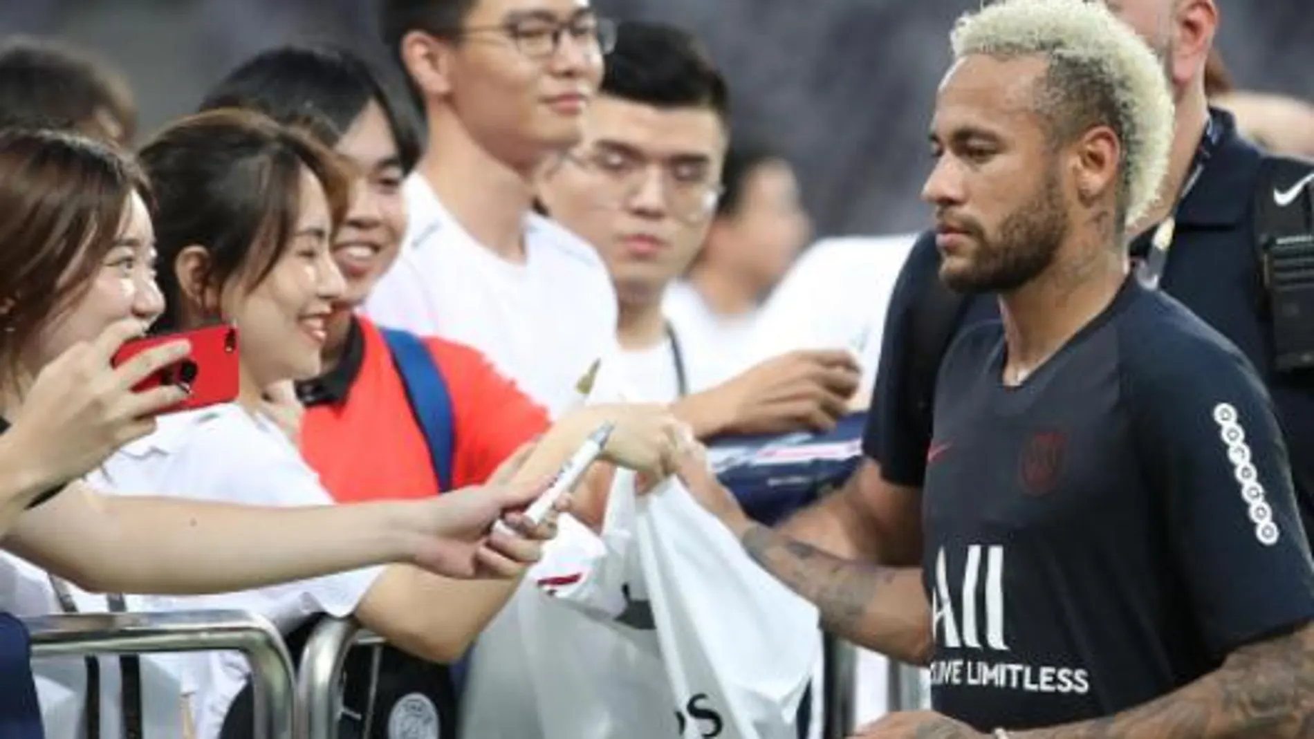 Neymar firma autógrafos a un grupos de aficionados