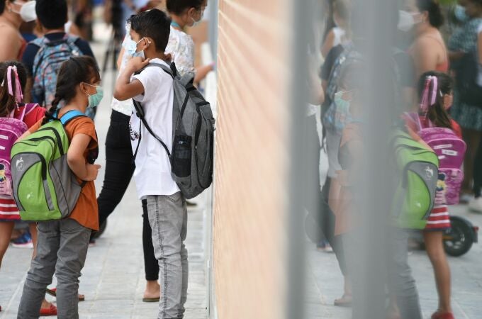 Varios niños esperan a la puertas del colegio Les Arts, de reciente construcción, durante el primer día del curso escolar 2021-2022 en la Comunidad Valenciana