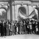 Fernández Flórez vivió en primera persona el terror de los días bélicos de Madrid. En la imagen, frente a la Puerta de Alcalá, un grupo de madrileños con una bandera nacional, espera la llegada de las tropas de Franco.