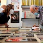 Isabel Díaz Ayuso, junto al escritor Fernando Aramaburu, durante su visita este sábado a la Feria del Libro de Madrid que celebra su 80ª edición en el Paseo de Coches del Retiro.