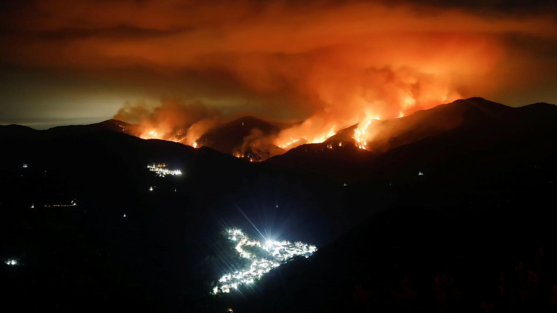 Las llamas del incendio en Sierra Bermeja; a la izquierda, la localidad de Genalguacil y en el centro, Benarraba