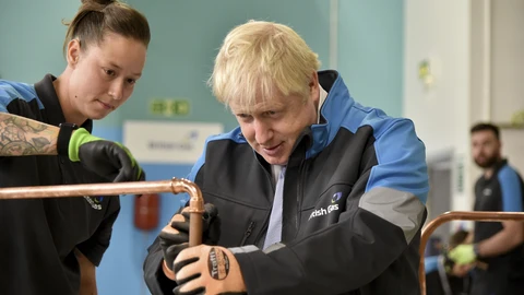 Boris Johnson supervisa una tubería de cobre en una escuela de formación