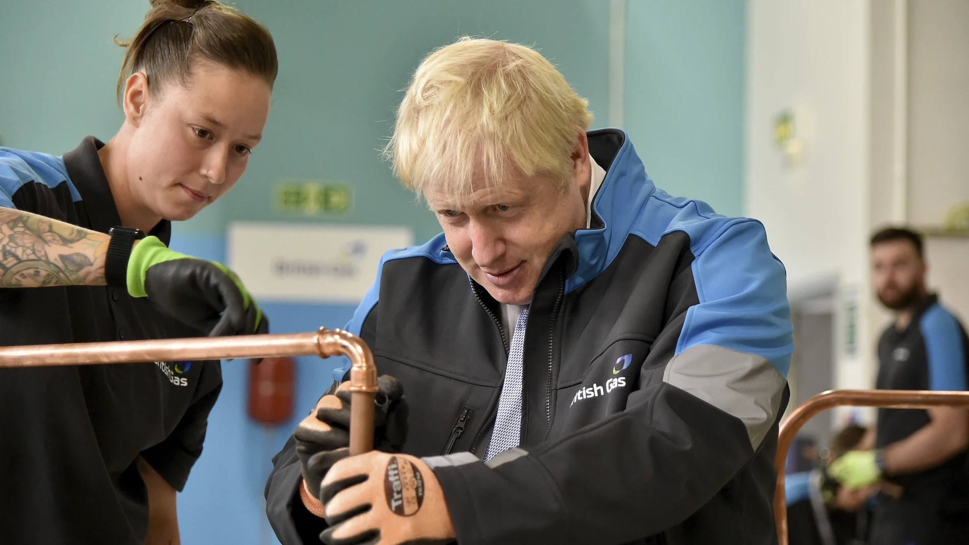 Boris Johnson supervisa una tubería de cobre en una escuela de formación