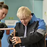 Boris Johnson supervisa una tubería de cobre en una escuela de formación