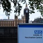 Cartel indicando un punto de vacunación a las afueras del Parlamento británico