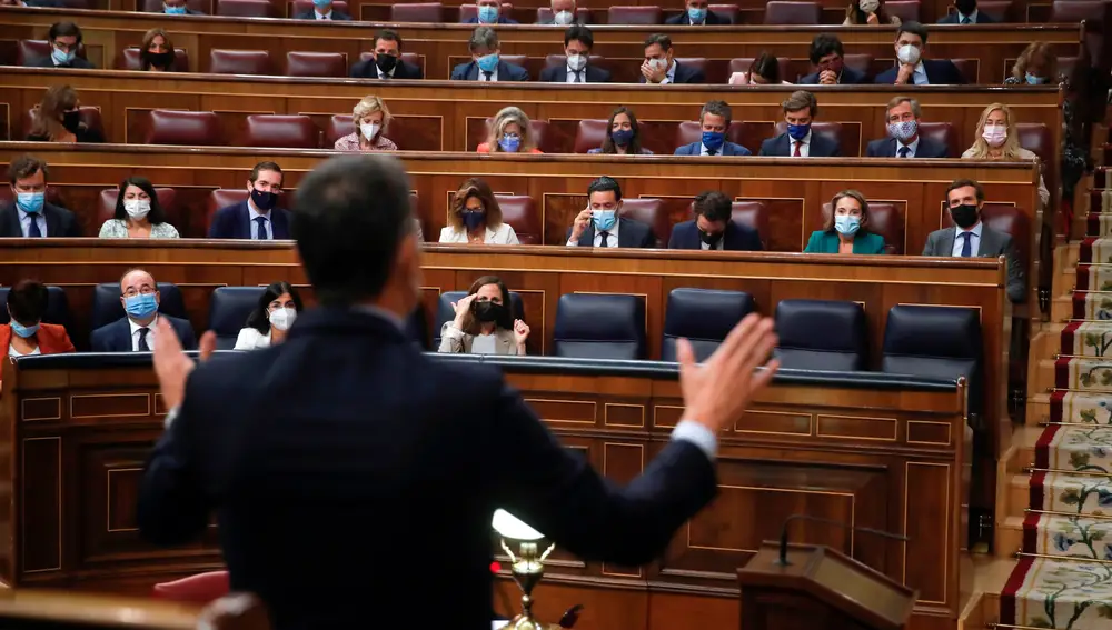 El presidente del Gobierno, Pedro Sánchez (de espaldas), responde al líder del PP, Pablo Casado