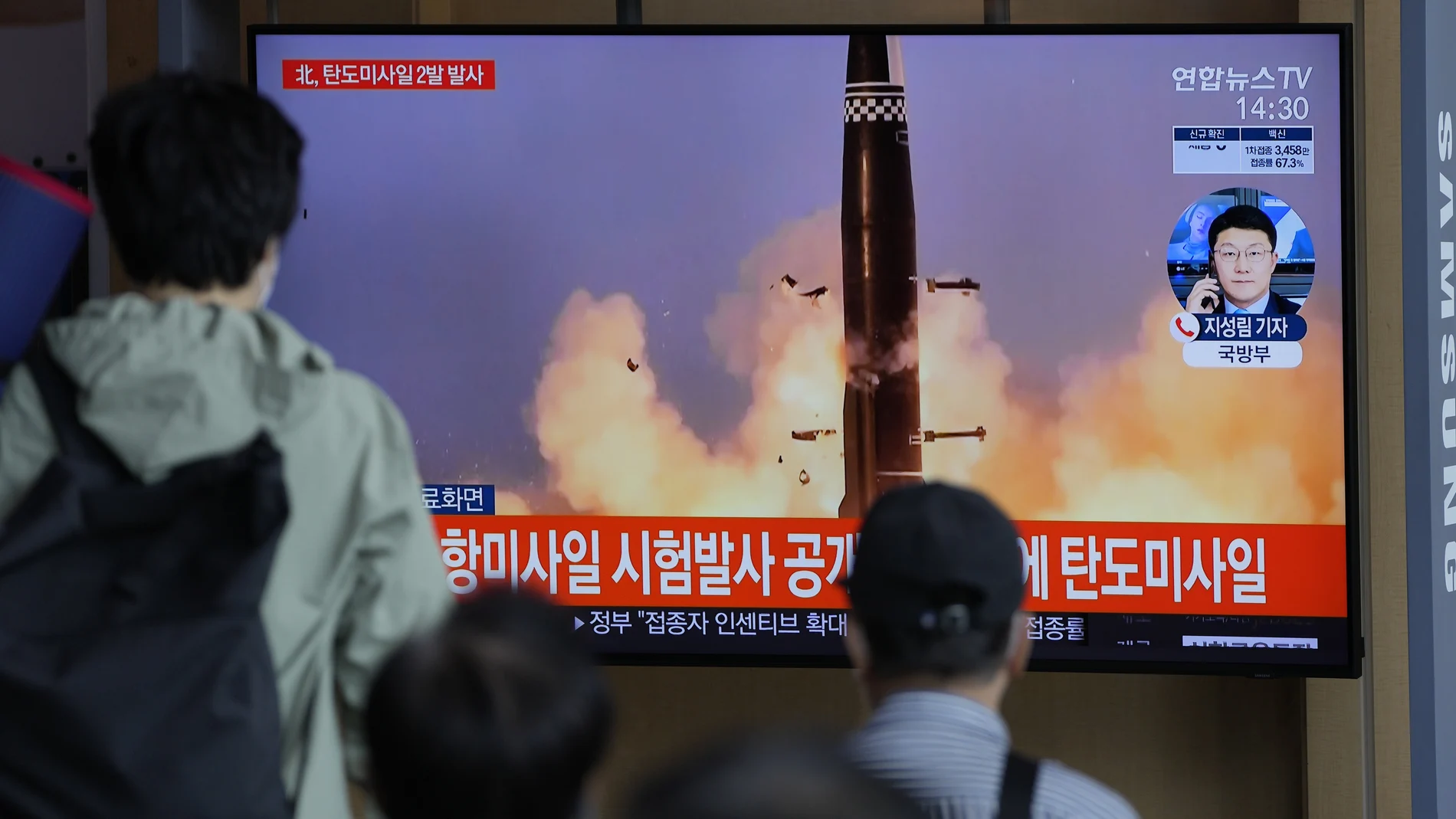 Varias personas miran en Seúl el lanzamiento de misiles de Corea del Norte