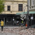 Emergency workers survey damage in Melbourne, Australia, where debris is scattered on a road after part of a wall fell from a building during an earthquake, Wednesday, Sept. 22, 2021. A strong earthquake caused damage in the city of Melbourne in an unusually powerful temblor for Australia, Geoscience Australia said. (James Ross/AAP Image via AP)