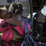 A child sleeps on the shoulder of a woman as they prepare to board a bus to San Antonio moments after a group of migrants, many from Haiti, were released from custody upon crossing the Texas-Mexico border in search of asylum, Wednesday, Sept. 22, 2021, in Del Rio, Texas. (AP Photo/Julio Cortez)
