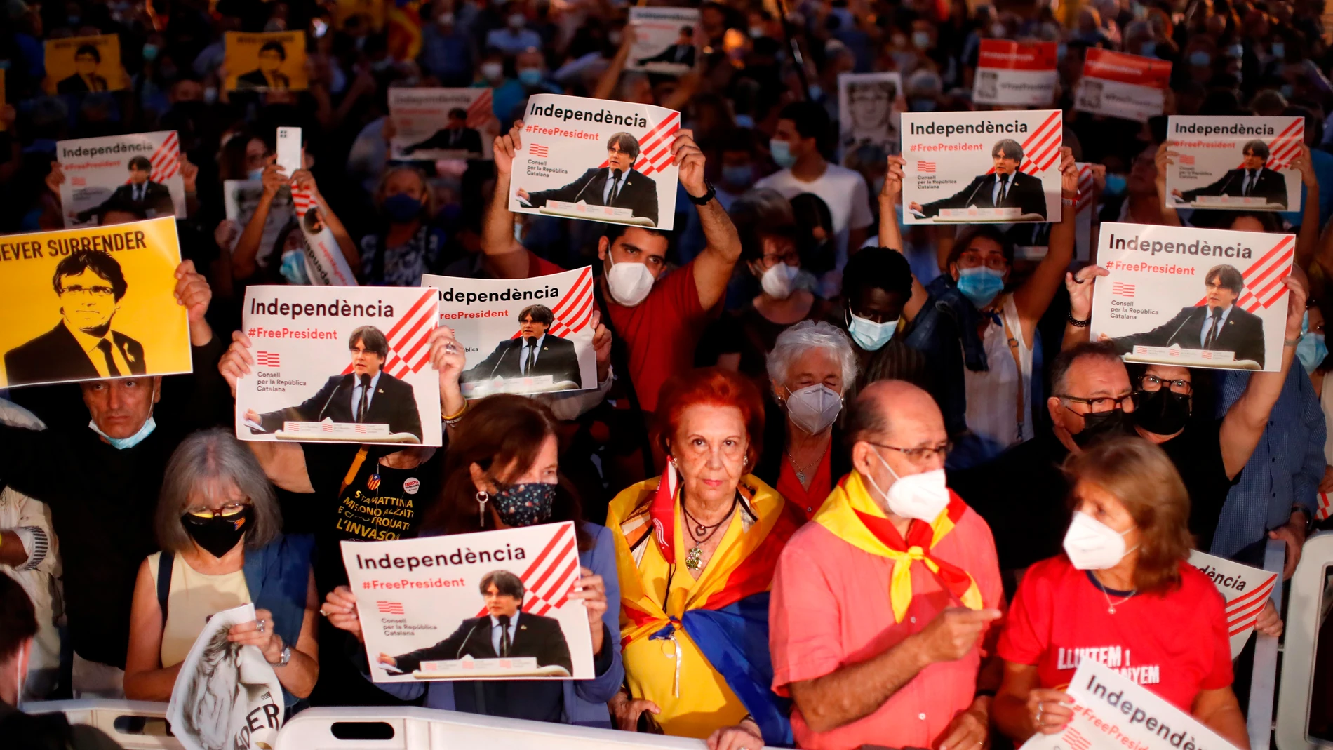 Varias personas sostienen retratos del expresidente de la Generalitat Carles Puigdemont durante las fiestas de la Mercé