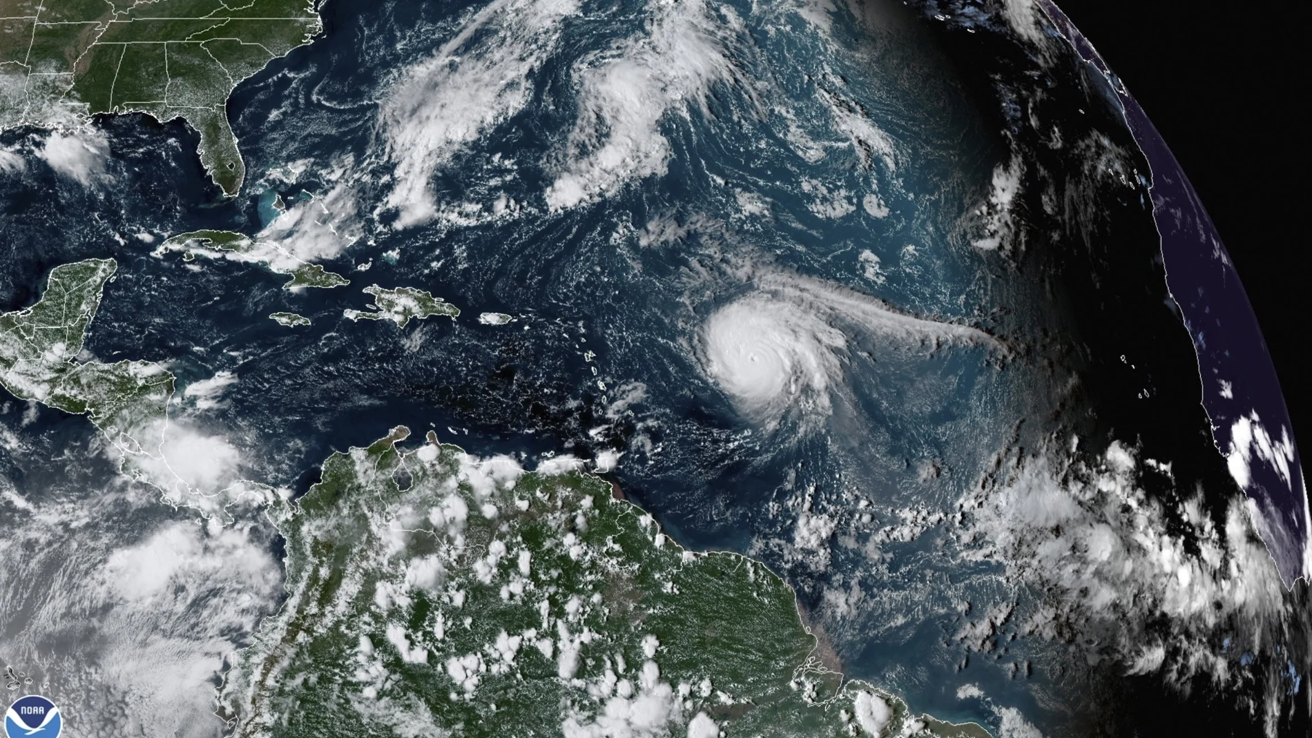 This satellite image provided by the National Oceanic and Atmospheric Administration shows Hurricane Sam, just right of center, in the Atlantic Ocean, Monday, Sept. 27, 2021, at 1920 Zulu (3:20 p.m. ET). Sam is a powerful Category 4 storm but it poses no threat to land as it loops northward in the Atlantic, according to the U.S. National Hurricane Center. (NOAA via AP)