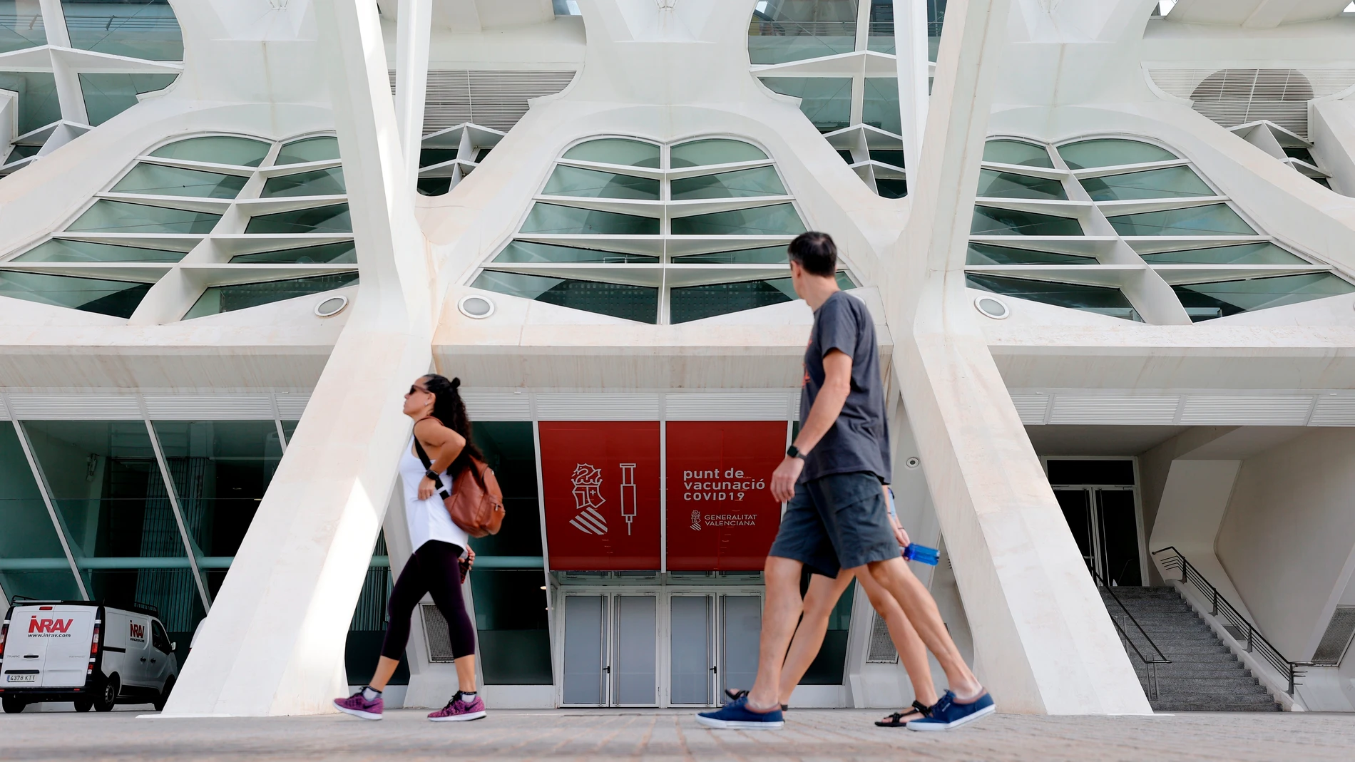 Dos personas pasan ante el centro de vacunación masiva en la Ciudad de las Ciencias de Valencia, que ayer cerró sus puertas tras inocular 5.300.000 en estos centros
