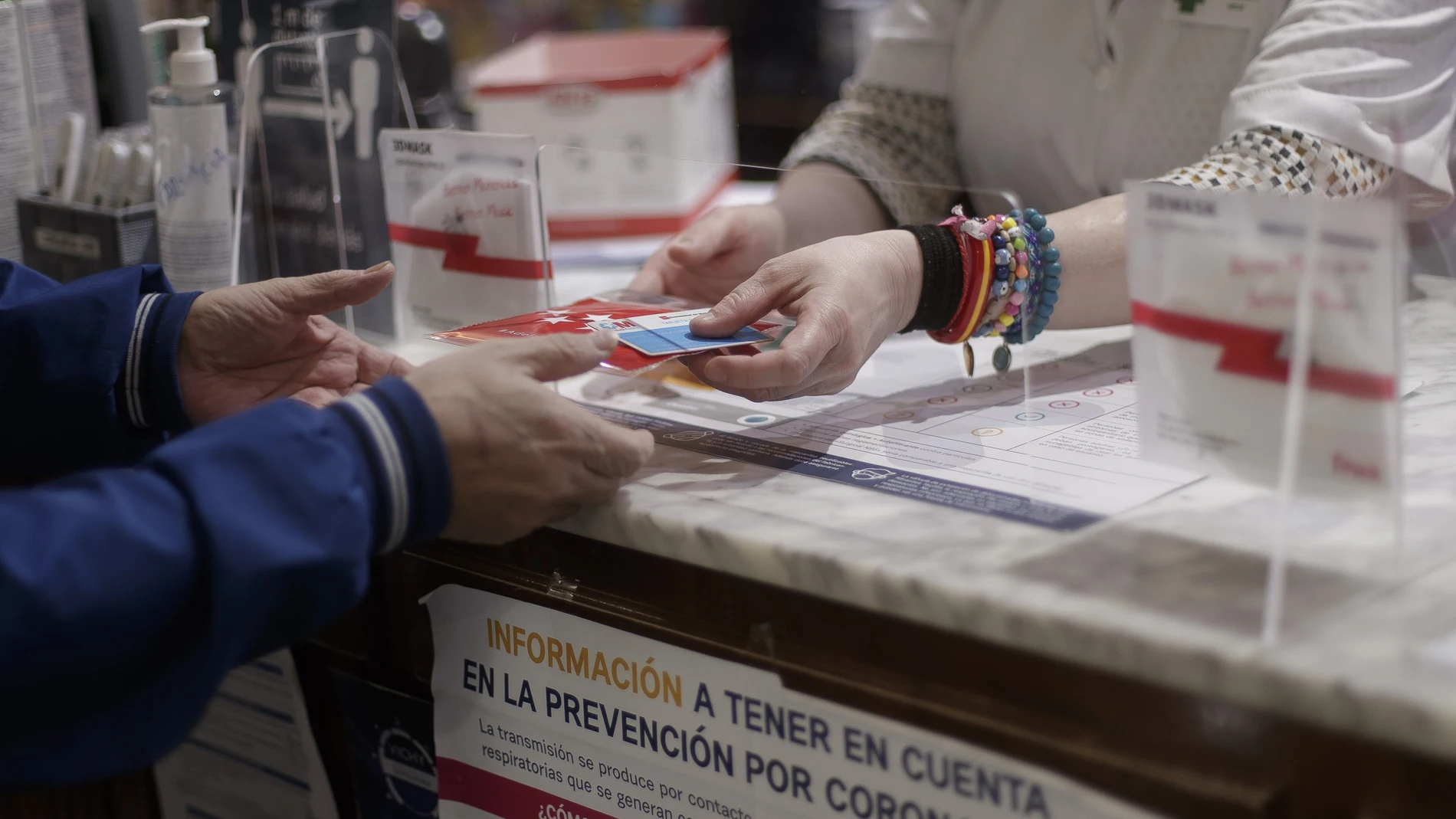 Una persona recoge una mascarilla de una de las 2.882 farmacias madrileñas