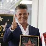 Spanish musician Alejandro Sanz holds a replica of his new star on the Hollywood Walk of Fame following a ceremony, Friday, Oct. 1, 2021, in Los Angeles. (AP Photo/Chris Pizzello)