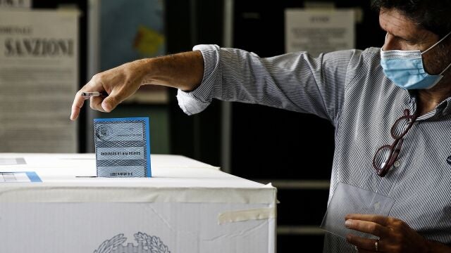 Un hombre deposito su voto en una urna de un colegio electoral de Roma