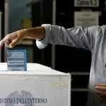 Un hombre deposito su voto en una urna de un colegio electoral de Roma