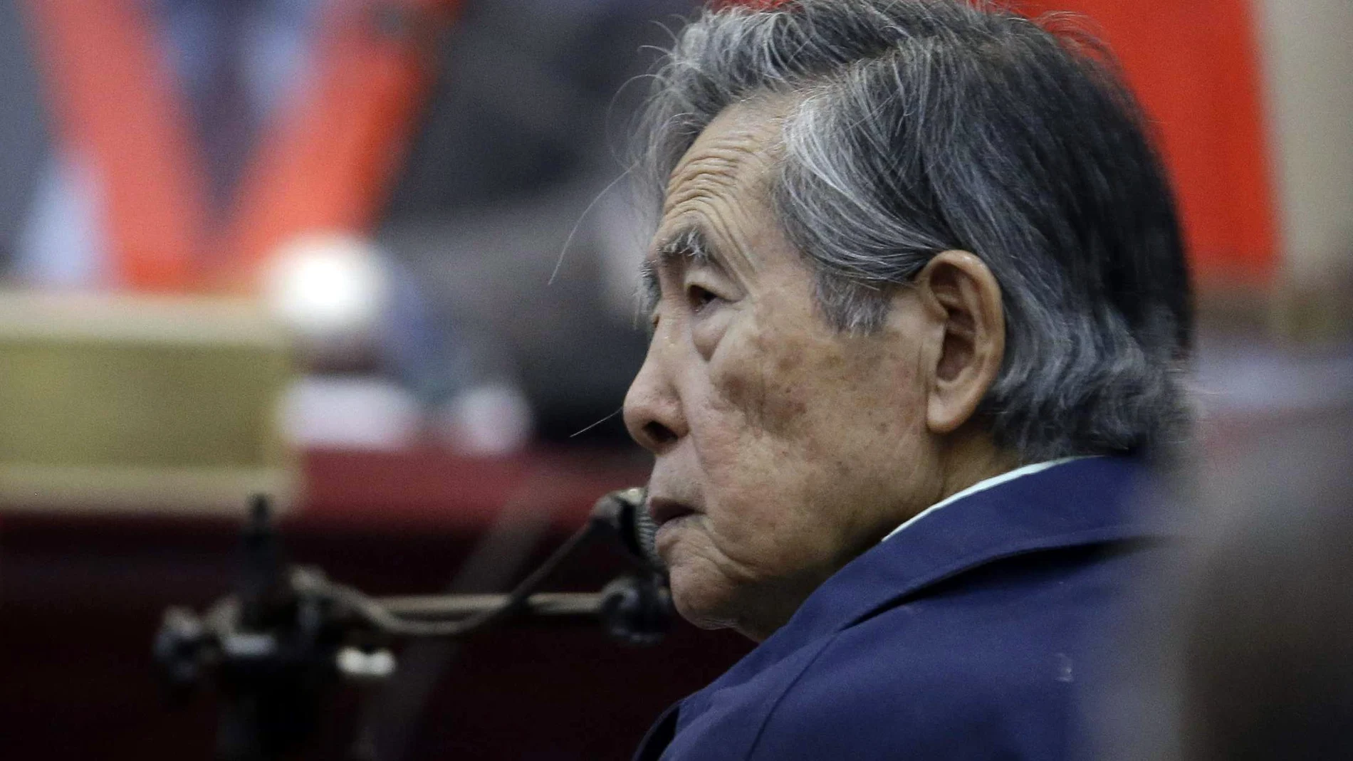 FILE - In this March 15, 2018 file photo, Peru's former President Alberto Fujimori listens to a question during his testimony in a courtroom at a military base in Callao, Peru. The government of Peru said Monday, Oct. 4, 2021, that Fujimori who is serving a 25-year prison sentence for human rights violations and corruption, will be having an invasive cardiac procedure and will admitted to the the ICU of a local clinic. (AP Photo/Martin Mejia, File)